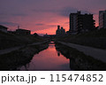 夕焼けに染まる住宅街の川 115474852