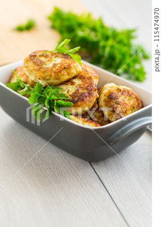 fried meat cutlets in a ceramic form on a wooden table 115474970