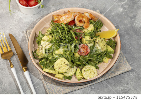 Salad with cucumbers and arugula, shrimp and cherry tomatoes in a light sauce. Salad with cucumbers and arugula, shrimp and cherry tomatoes in a light sauce. 115475378