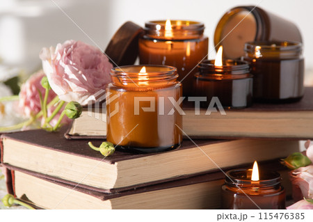 A set of different aroma candles in brown glass jars. Scented handmade candle. Soy candles are burning in a jar. Aromatherapy and relax in spa and home. Still life. Fire in brown jar A set of different aroma candles in brown glass jars. Scented handmade candle. Soy candles are burning in a jar. Aromatherapy and relax in spa and home. Still life. Fire in brown jar 115476385