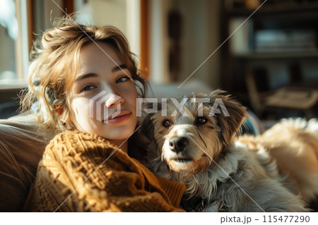 Caucasian woman is sitting on the sofa with her dog in the living room. 115477290