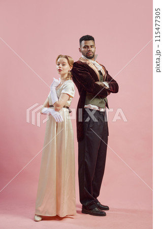 Elegant Alliance. A man and woman dressed in elegant renaissance costumes, stand back-to-back and posing against pink studio background 115477305