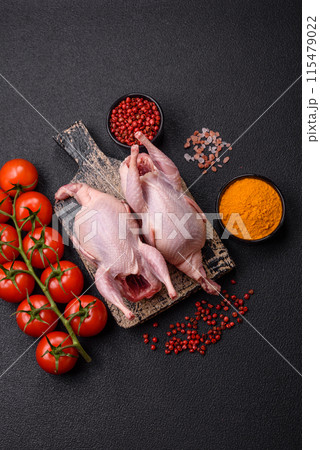 Whole raw quails with salt, spices and herbs on a dark concrete background 115479022