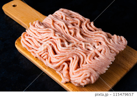 Minced meat on wood with a fork. Fashionable photo of minced meat with space for text. Minced meat on wood with a fork. Fashionable photo of minced meat with space for text. 115479657