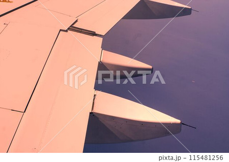 wing of an airplane flying above the clouds 115481256