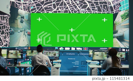 Shipping agency workers examine satellite map with huge greenscreen display, monitoring parcels and orders for clients. Employees using surveillance CCTV footage to get updates. Camera B. Shipping agency workers examine satellite map with huge greenscreen display, monitoring parcels and orders for clients. Employees using surveillance CCTV footage to get updates. Camera B. 115481314