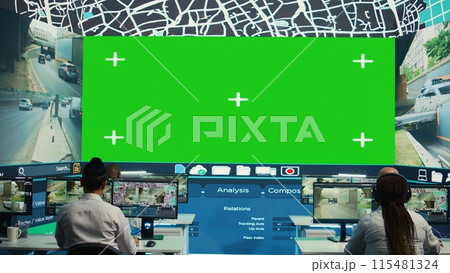 Group of employees monitoring delivery trucks routes with an isolated screen, working with satellite map and radar. Diverse people look at greenscreen display, order tracking. Camera B. 115481324