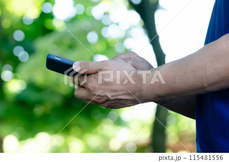 スマホを持つ男性スタッフの手元 115481556