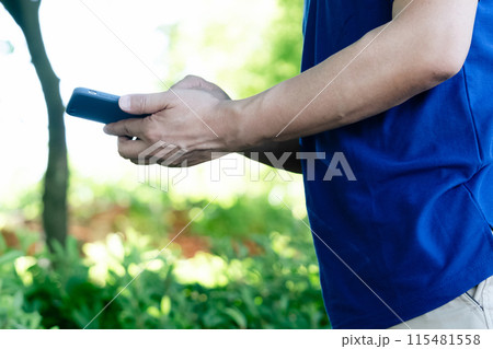 スマホを持つ男性スタッフの手元 115481558