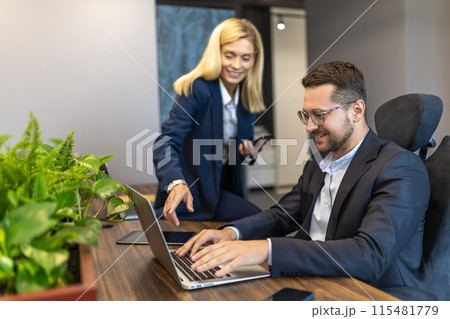 Professional businesspeople working together on online project in office interior Professional businesspeople working together on online project in office interior 115481779