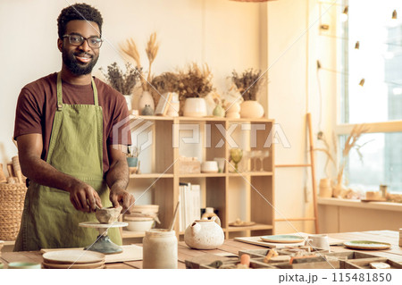 African american young man working with clay in pottery studio 115481850