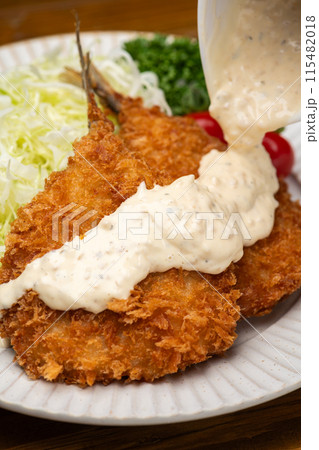 アジフライにタルタルソースをかけて食べる アジフライにタルタルソースをかけて食べる 115482018