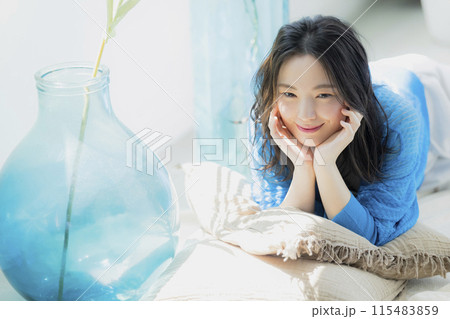 仰向けに寝転がる青い服の女性 仰向けに寝転がる青い服の女性 115483859