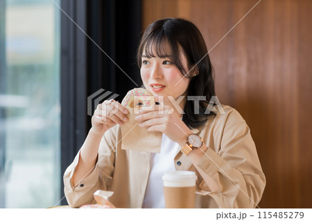 カフェでドーナツを食べる女性 115485279