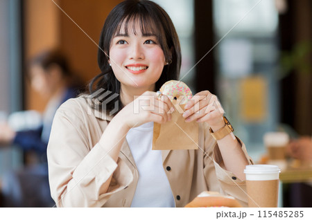 カフェでドーナツを食べる女性 115485285