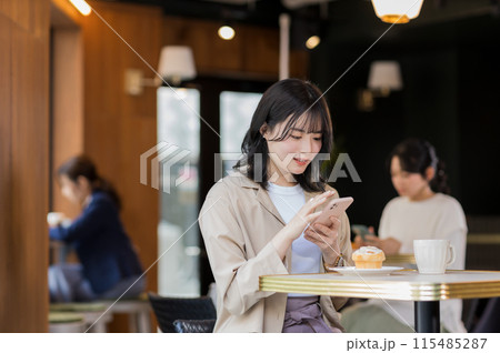カフェでスマホを操作する若い女性 カフェでスマホを操作する若い女性 115485287