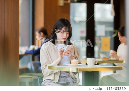 カフェでスマホを操作する若い女性 115485289