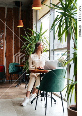 Woman Sitting at Table With Laptop Woman Sitting at Table With Laptop 115485951