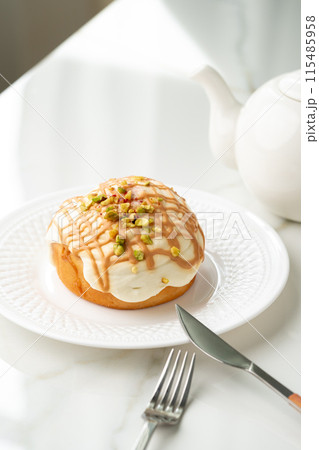 Cinnamon roll bun with icing on plate Cinnamon roll bun with icing on plate 115485958