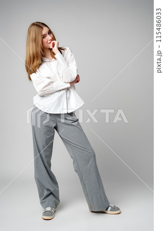 Joyful Young Blonde Woman Smiling against gray background Joyful Young Blonde Woman Smiling against gray background 115486033