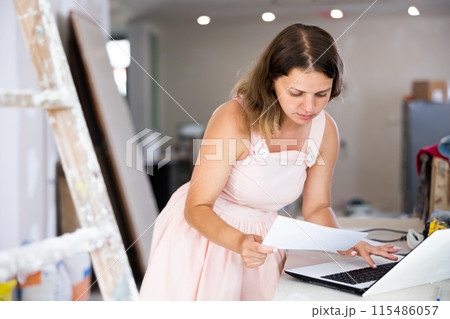 Woman designer using laptop in construction site 115486057