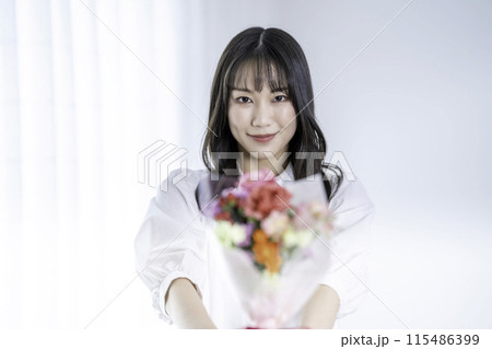 花束を渡す女性 115486399