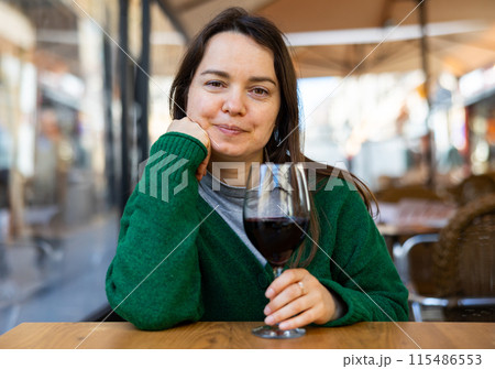 Young adult woman drinking wine at restaurant Young adult woman drinking wine at restaurant 115486553