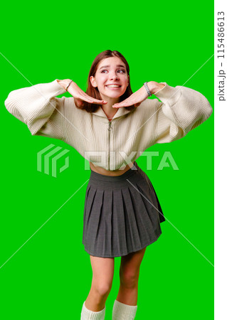 Smiling Young Woman Posing in Casual Clothing Against a Green Background Smiling Young Woman Posing in Casual Clothing Against a Green Background 115486613