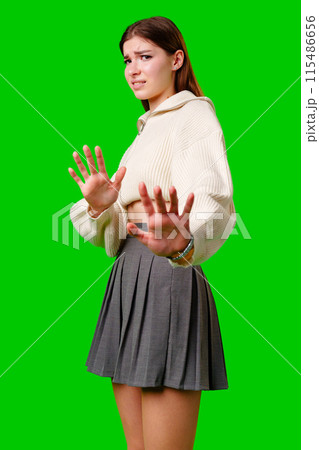 Young Woman Gesturing Stop With Both Hands Against a Green Background Young Woman Gesturing Stop With Both Hands Against a Green Background 115486656