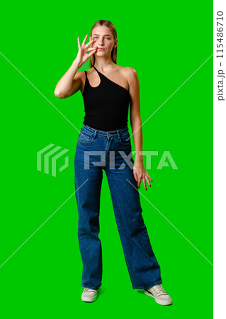 Young Woman Gesturing Silence With Finger on Lips Against Green Screen Background Young Woman Gesturing Silence With Finger on Lips Against Green Screen Background 115486710