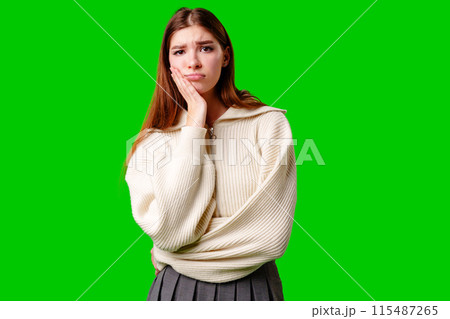 Young Woman Looking Bored and Disinterested Against Green Background 115487265