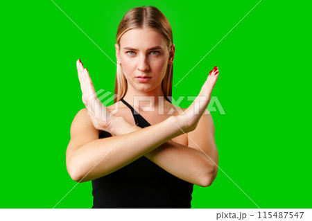 Young Woman Making Stop Sign Gesture on green background Young Woman Making Stop Sign Gesture on green background 115487547