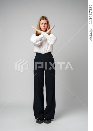 Young Woman Making X Sign With Arms to Express Prohibition or Disagreement 115487589