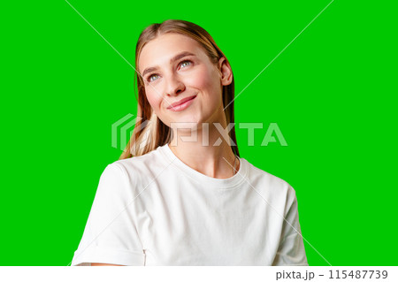 Young Woman in White Shirt Posing for Picture against green background 115487739
