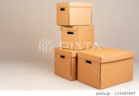 Pile of brown moxing boxes on grey background Pile of brown moxing boxes on grey background 115487807