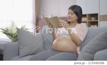 A Portrait of happy Asian pregnant woman in bedroom at home. Having a baby. Family people lifestyle. Love. A Portrait of happy Asian pregnant woman in bedroom at home. Having a baby. Family people lifestyle. Love. 115488366