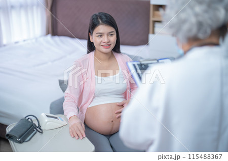 A portrait of happy Asian pregnant woman checkup with a doctor in bedroom at home. Having a baby. Family people lifestyle. Mom love. 115488367