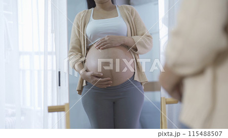 A Portrait of happy Asian pregnant woman in bedroom at home. Having a baby. Family people lifestyle. Love. 115488507