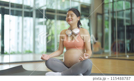 A portrait of happy Asian pregnant woman at gym fitness center club. Having a baby. Training workout. Exercise indoor with sport equipment. Athletic. Family people lifestyle. Mom love. Recreation. 115488787