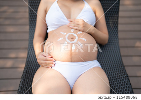 A portrait of happy Asian pregnant woman by the swimming pool. People lifestyle in travel holiday vacation concept. Relaxation. Having a baby. Family people lifestyle. Mom love. A portrait of happy Asian pregnant woman by the swimming pool. People lifestyle in travel holiday vacation concept. Relaxation. Having a baby. Family people lifestyle. Mom love. 115489068