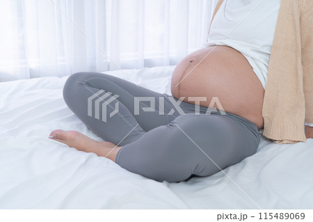 Close up of a Portrait of happy pregnant woman in bedroom at home. Having a baby. Family people lifestyle. Mom love. 115489069