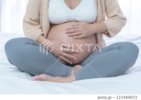 Close up of a Portrait of happy pregnant woman in bedroom at home. Having a baby. Family people lifestyle. Mom love. Close up of a Portrait of happy pregnant woman in bedroom at home. Having a baby. Family people lifestyle. Mom love. 115489072