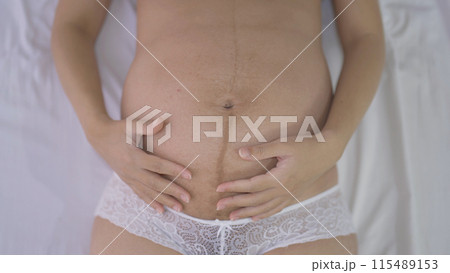 Close up of a Portrait of happy pregnant woman in bedroom at home. Having a baby. Family people lifestyle. Mom love. 115489153
