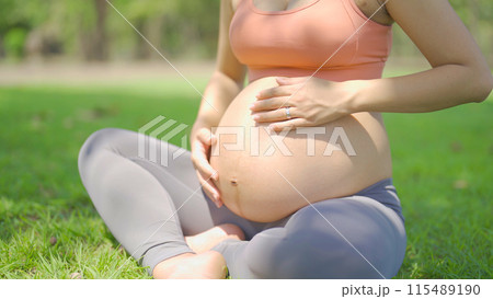 A portrait of happy Asian pregnant woman in yoga class club doing exercise at public garden park. Outdoor sport and recreation. activity with nature trees view. Having a baby. Family people lifestyle. A portrait of happy Asian pregnant woman in yoga class club doing exercise at public garden park. Outdoor sport and recreation. activity with nature trees view. Having a baby. Family people lifestyle. 115489190