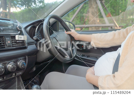 A Portrait of happy Asian pregnant woman driving a car vehicle. Having a baby. Family people lifestyle. Mom love. Journey. A Portrait of happy Asian pregnant woman driving a car vehicle. Having a baby. Family people lifestyle. Mom love. Journey. 115489204