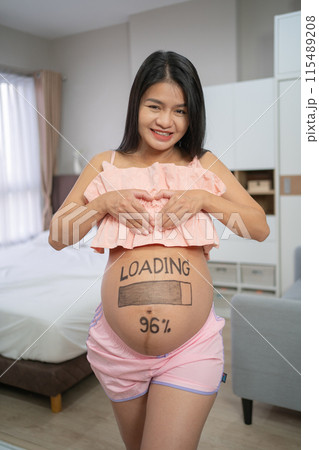 A portrait of happy Asian pregnant woman loading, counting down for baby in bedroom at home. Having a baby. Family people lifestyle. Mom love. A portrait of happy Asian pregnant woman loading, counting down for baby in bedroom at home. Having a baby. Family people lifestyle. Mom love. 115489208