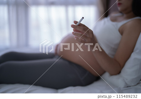 A Portrait of Asian pregnant woman smoking cigarette. Having a baby. Family people lifestyle. Mom love. 115489232