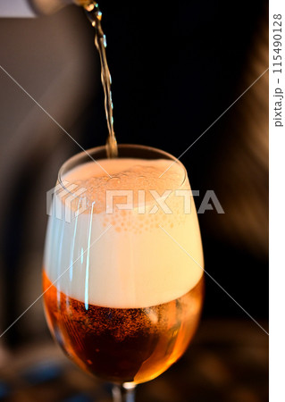 ワイングラスにビールを注いでいる様子 115490128