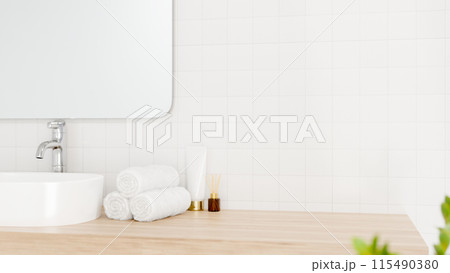 A close-up image of a wooden bathroom counter in a modern, minimalist bathroom. 115490380