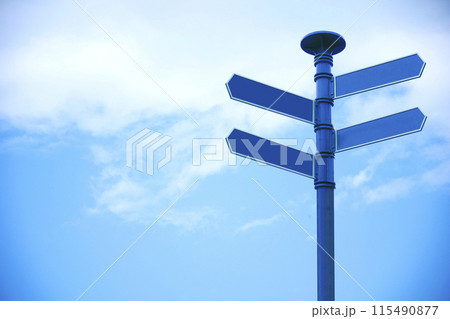 Blank direction sign with 4 arrowsn sky background. 115490877